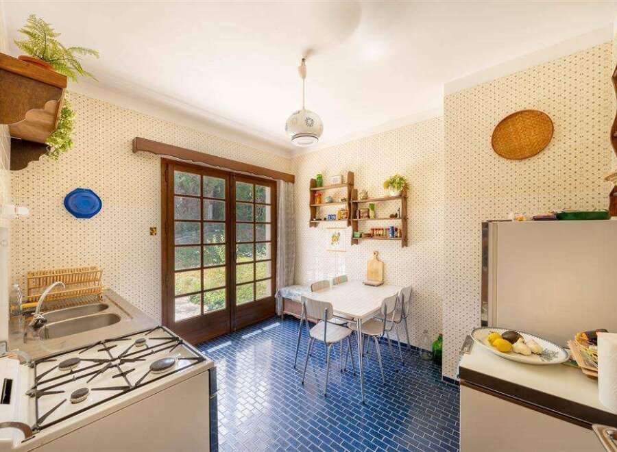 Step back in time in this charming vintage kitchen, featuring retro appliances and a delightful blue tiled floor.