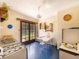 Step back in time in this charming vintage kitchen, featuring retro appliances and a delightful blue tiled floor.