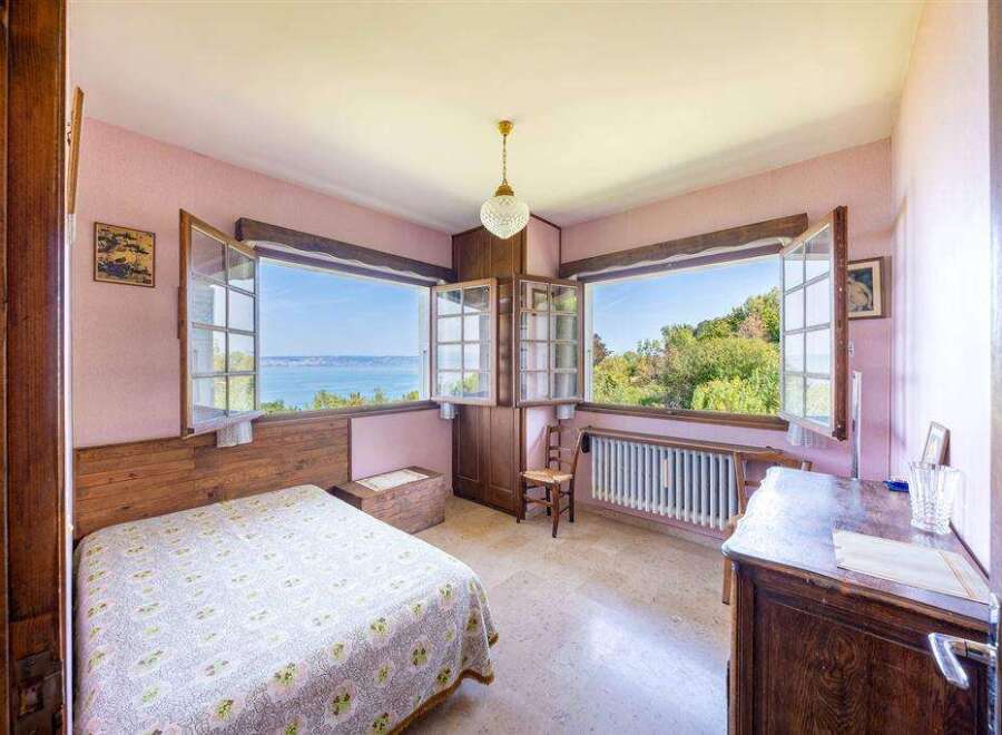 This charming bedroom boasts stunning lake views through its large windows, creating a serene and relaxing atmosphere.