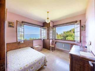 This charming bedroom boasts stunning lake views through its large windows, creating a serene and relaxing atmosphere.