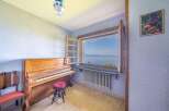 This stunning property boasts breathtaking lake views from a charming room featuring a vintage piano.