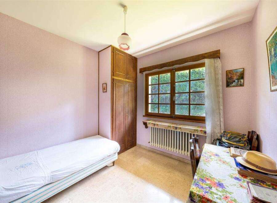 Charming bedroom with single bed, built-in wardrobe, and window overlooking garden.