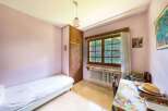 Charming bedroom with single bed, built-in wardrobe, and window overlooking garden.