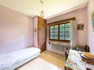 Charming bedroom with single bed, built-in wardrobe, and window overlooking garden.