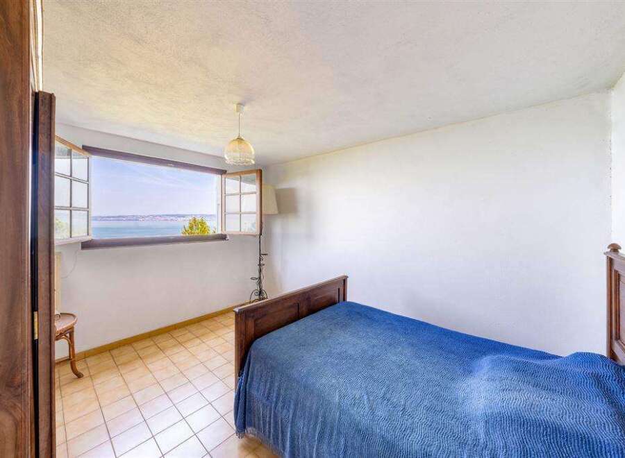 This charming bedroom boasts stunning lake views from its large window, creating a serene and relaxing atmosphere.