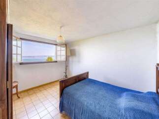 This charming bedroom boasts stunning lake views from its large window, creating a serene and relaxing atmosphere.