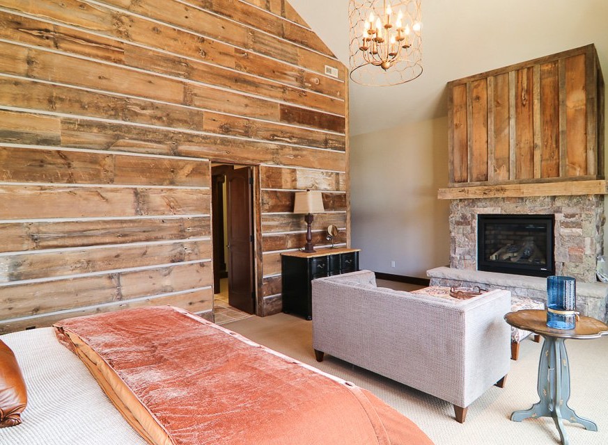 This luxurious bedroom boasts a stunning reclaimed wood wall, creating a rustic-chic atmosphere.