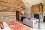 This luxurious bedroom boasts a stunning reclaimed wood wall, creating a rustic-chic atmosphere.