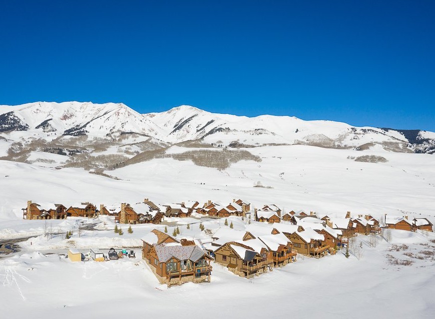 Luxury mountain homes nestled in a snowy landscape, offering breathtaking views and serene surroundings.