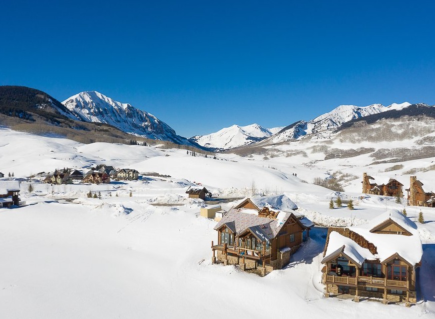 Luxury mountaintop homes nestled in a stunning winter landscape.