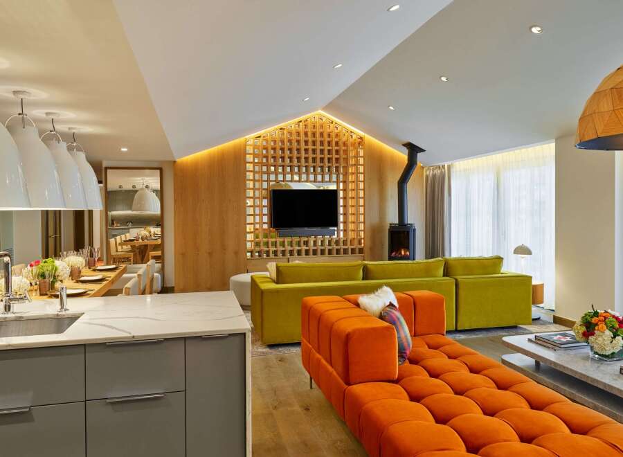 This luxurious living space boasts a stunning open-plan design, seamlessly blending a modern kitchen with a cozy living area.