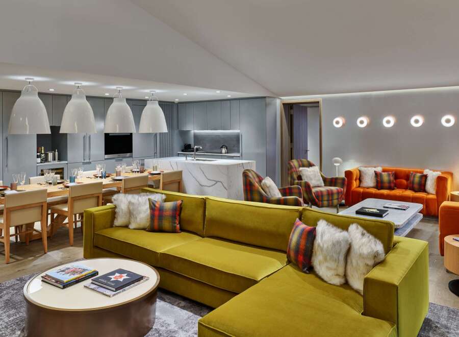 This luxurious living space boasts a spacious open floor plan seamlessly integrating a gourmet kitchen with a large dining table and a comfortable seating area.