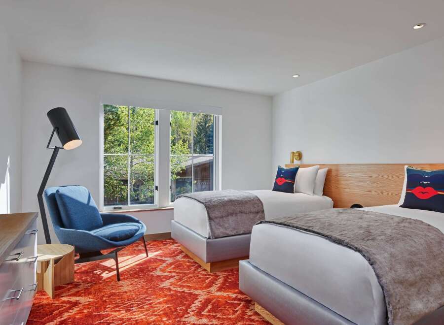 This bright and airy bedroom features two twin beds with plush gray throws, perfect for a relaxing stay.