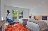 This bright and airy bedroom features two twin beds with plush gray throws, perfect for a relaxing stay.