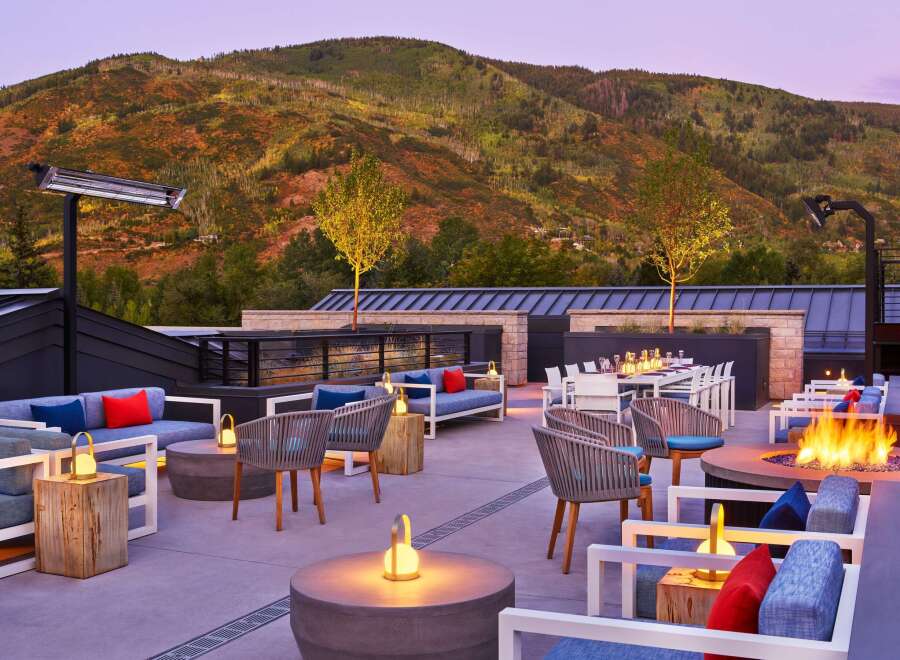 This rooftop lounge boasts stunning mountain views, cozy seating areas with fire pits and heaters, and a stylish dining space perfect for evening gatherings.