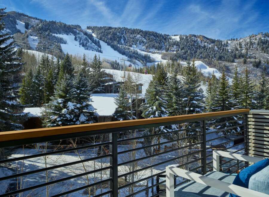 This luxurious property boasts breathtaking views of snow-capped mountains and a ski resort, all visible from a private balcony.