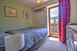 Cozy bedroom with a double bed and stunning mountain views from the balcony.