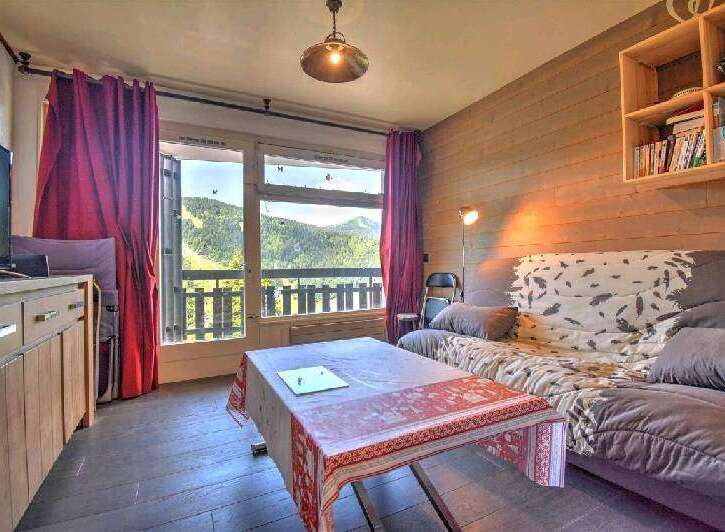 Mountain view apartment with balcony featuring a comfortable sofa bed, fully equipped kitchen and wooden flooring.