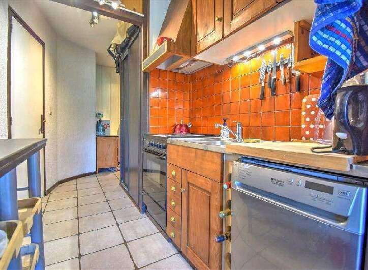 This charming apartment boasts a well-equipped kitchen with ample cabinetry and modern appliances, including a dishwasher.