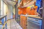 This charming apartment boasts a well-equipped kitchen with ample cabinetry and modern appliances, including a dishwasher.