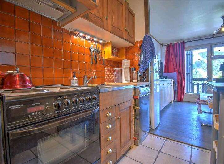 Cozy kitchen with orange tile backsplash and wooden cabinetry.