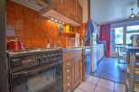 Cozy kitchen with orange tile backsplash and wooden cabinetry.