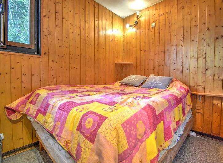 Cozy cabin room with wood paneling and a comfortable bed.