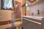 This charming bathroom boasts a modern sink and vanity, complemented by stylish tiled walls.
