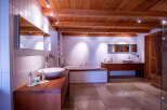 Luxurious bathroom with wooden beams and tiled walls.