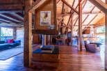 This stunning chalet boasts a spacious open-plan living area with exposed wooden beams and a large stone fireplace, creating a warm and inviting atmosphere.