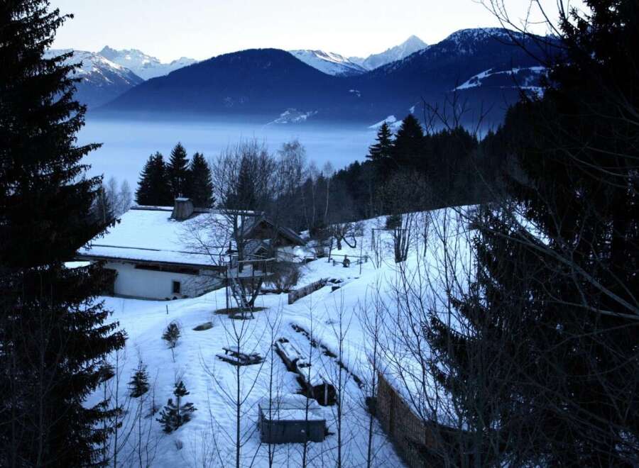 Secluded mountain chalet nestled in a snowy landscape, offering breathtaking views.