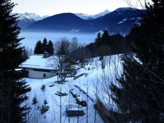 Secluded mountain chalet nestled in a snowy landscape, offering breathtaking views.