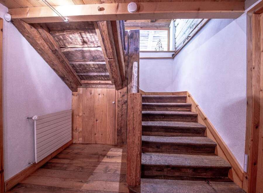 This charming property boasts a rustic wooden staircase, adding character and warmth to the home.