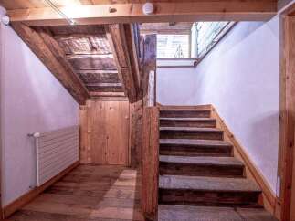 This charming property boasts a rustic wooden staircase, adding character and warmth to the home.