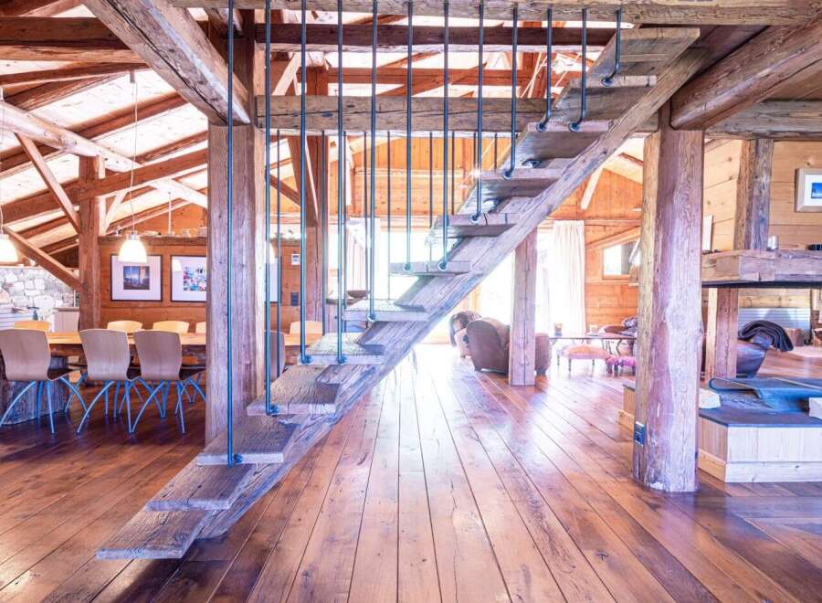 This stunning chalet boasts a unique, rustic-chic interior with exposed wooden beams and a magnificent reclaimed wood staircase.