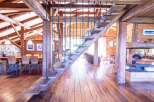 This stunning chalet boasts a unique, rustic-chic interior with exposed wooden beams and a magnificent reclaimed wood staircase.
