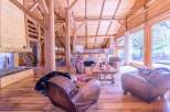 This stunning chalet boasts a spacious open-plan living area with exposed wooden beams and large windows offering breathtaking views.