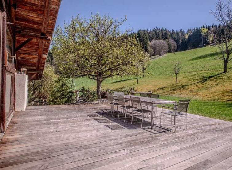 This stunning property boasts a spacious wooden deck, perfect for outdoor dining and relaxation.