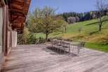 This stunning property boasts a spacious wooden deck, perfect for outdoor dining and relaxation.