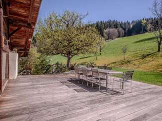 This stunning property boasts a spacious wooden deck, perfect for outdoor dining and relaxation.