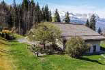 Mountain view chalet with spacious lawn and wooden deck.