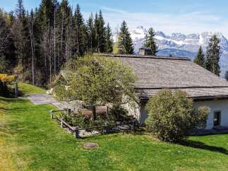Mountain view chalet with spacious lawn and wooden deck.