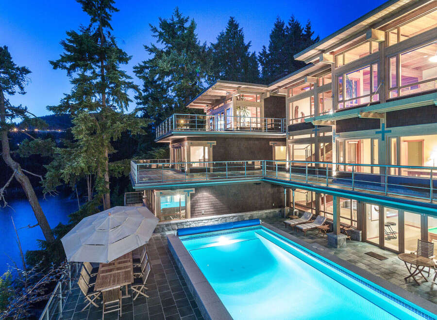 Luxury waterfront home with stunning night views, featuring a multi-level design, expansive decks, and a private infinity pool.
