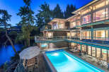 Luxury waterfront home with stunning night views, featuring a multi-level design, expansive decks, and a private infinity pool.