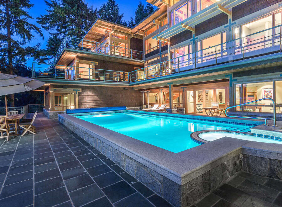 This luxurious waterfront home boasts a stunning outdoor oasis, complete with a large, inviting pool and spa.