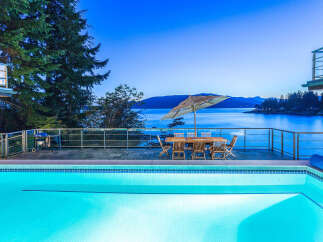 Luxury waterfront property boasts stunning sunset views and a private infinity pool.