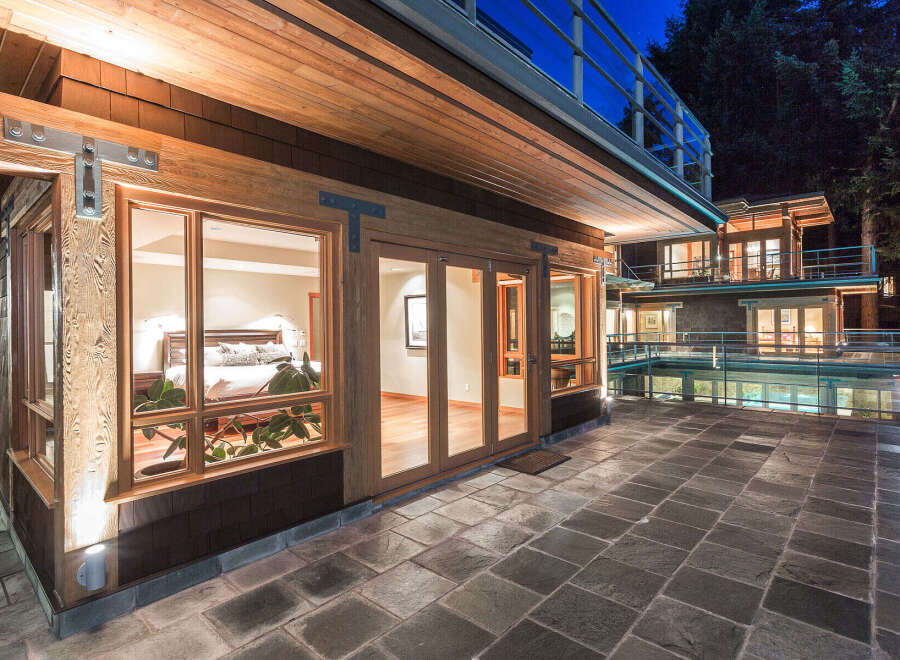 This stunning property boasts a luxurious master bedroom with large windows offering breathtaking views, a spacious patio perfect for outdoor entertaining, and a modern design that seamlessly blends indoor and outdoor living.