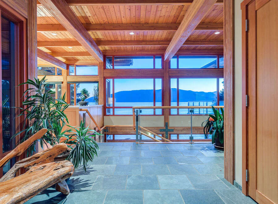 This stunning home boasts a spacious open-concept design with expansive windows offering breathtaking views of the water and mountains.