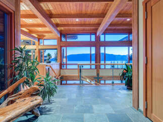 This stunning home boasts a spacious open-concept design with expansive windows offering breathtaking views of the water and mountains.