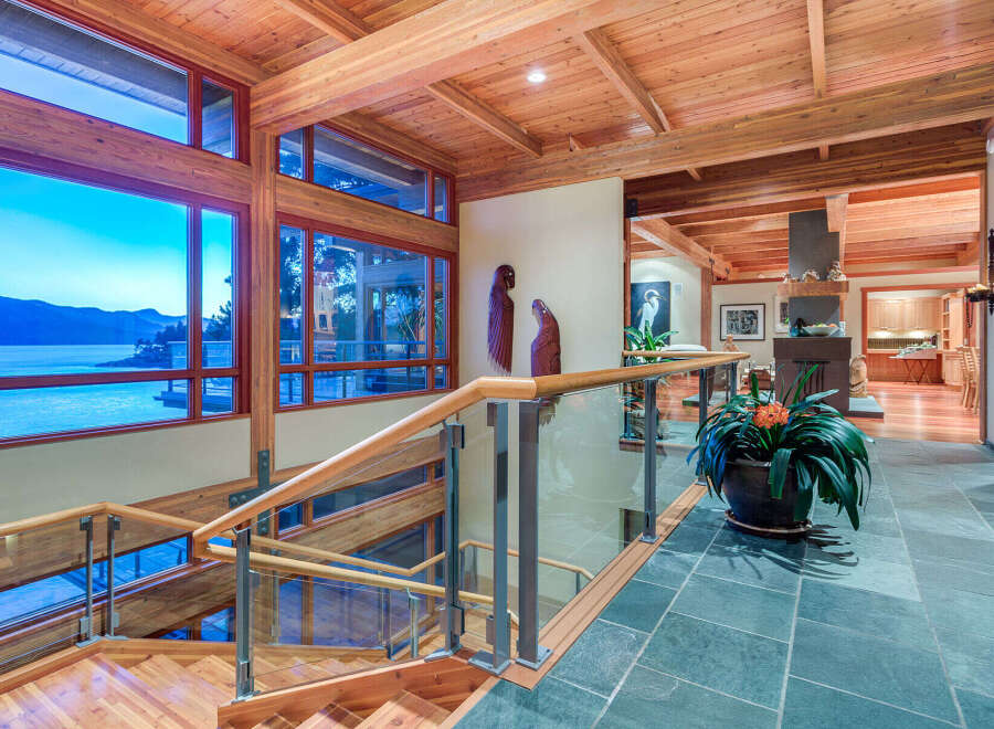This stunning home boasts a spacious open floor plan with walls of windows offering breathtaking water views.